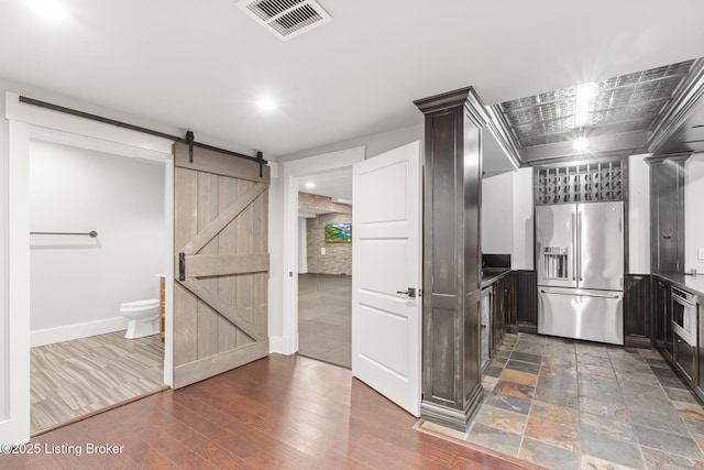 kitchen featuring dark hardwood / wood-style flooring, high quality fridge, and a barn door