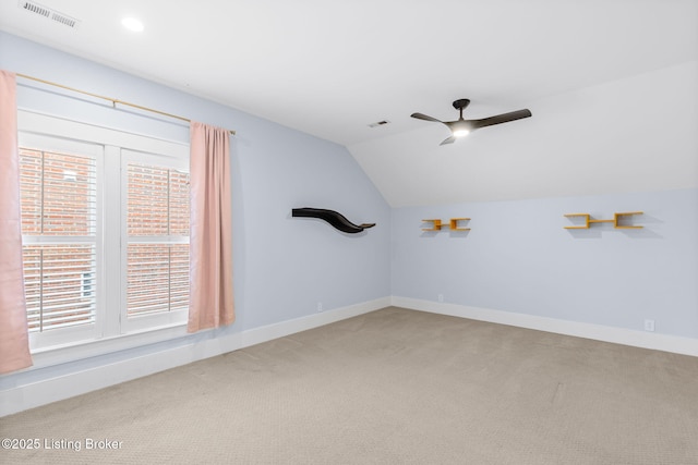 spare room with carpet floors, vaulted ceiling, and ceiling fan