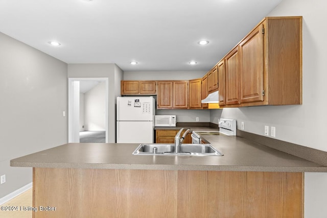 kitchen featuring kitchen peninsula, sink, and white appliances