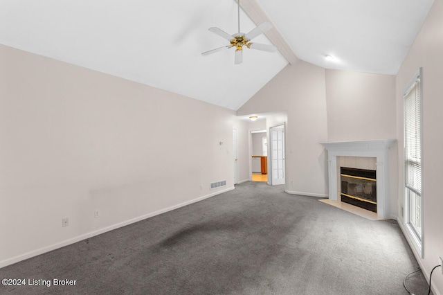 unfurnished living room with a tile fireplace, ceiling fan, beamed ceiling, high vaulted ceiling, and carpet