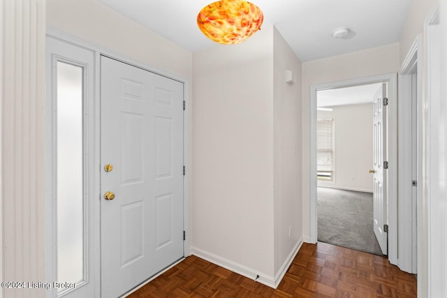 foyer entrance featuring dark parquet flooring