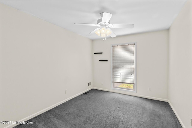 spare room featuring ceiling fan and dark colored carpet