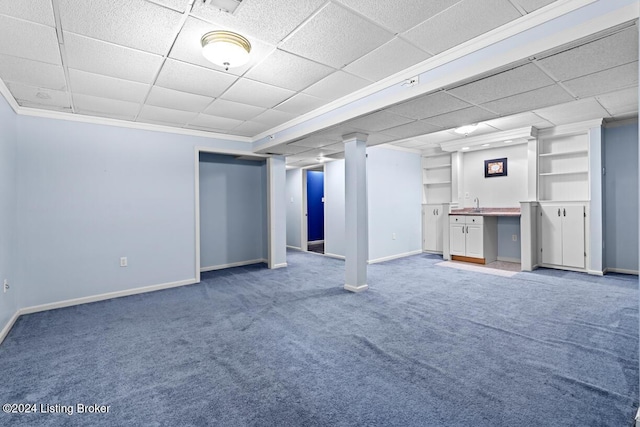 basement featuring carpet flooring, built in shelves, and ornamental molding