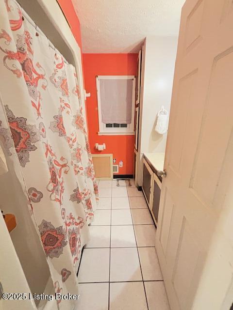 bathroom featuring tile patterned flooring and a textured ceiling