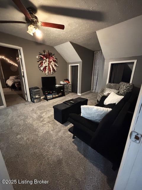 carpeted living room featuring ceiling fan, a textured ceiling, and vaulted ceiling