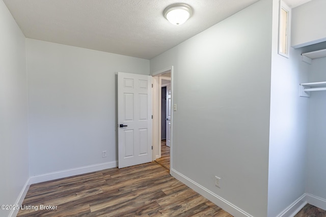 empty room featuring dark wood-type flooring and a textured ceiling