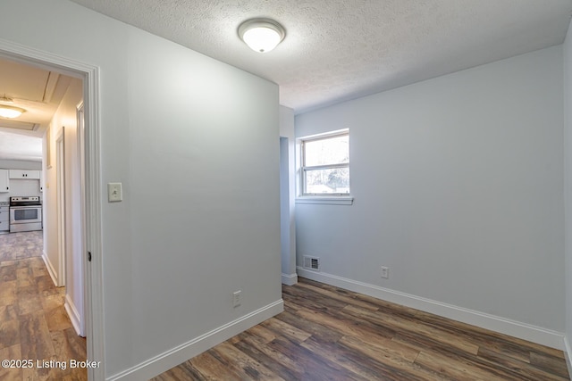 unfurnished room featuring a textured ceiling and dark hardwood / wood-style floors