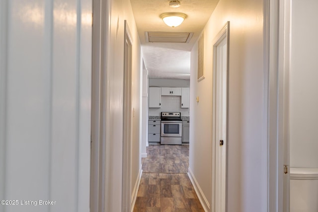 hall with a textured ceiling and dark hardwood / wood-style floors