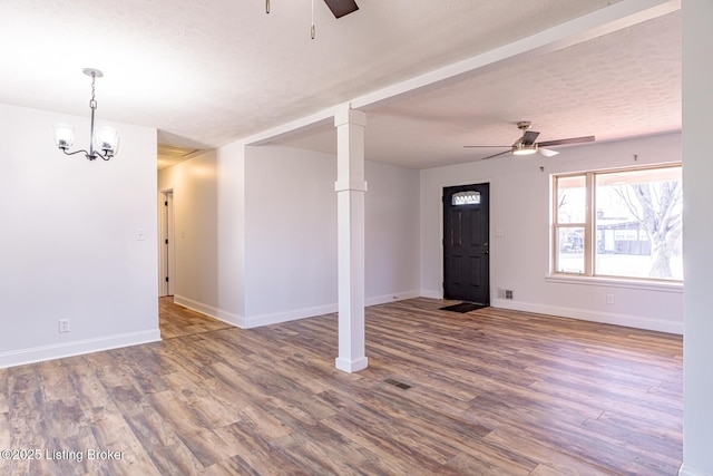 interior space with ceiling fan with notable chandelier, a textured ceiling, and hardwood / wood-style flooring