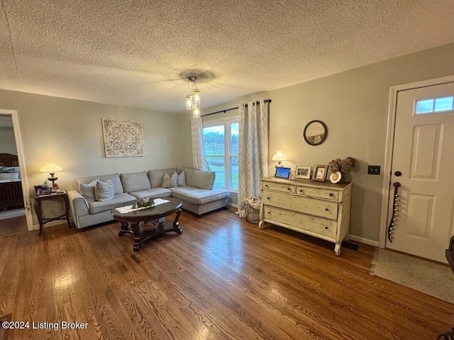 living room with a textured ceiling and dark hardwood / wood-style floors