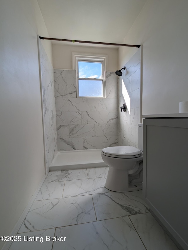 bathroom featuring a tile shower and toilet