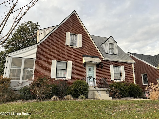 view of front facade with a sunroom and a front yard