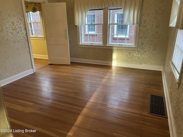 unfurnished room with dark wood-type flooring