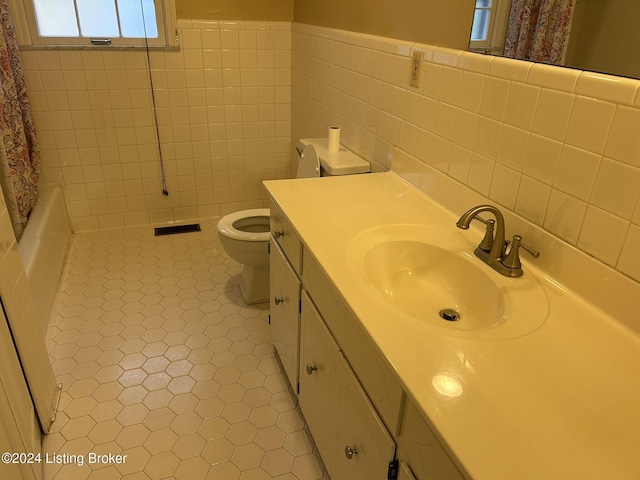 full bathroom with tile patterned flooring, vanity, toilet, and tile walls