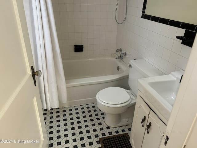 full bathroom featuring vanity, tile patterned flooring, toilet, shower / bathtub combination with curtain, and tile walls