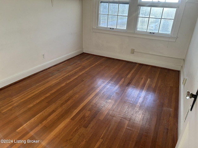 unfurnished room with dark wood-type flooring and a wealth of natural light