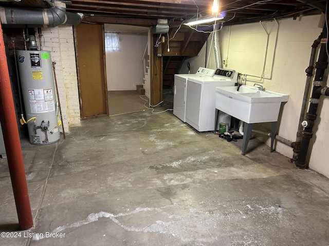 basement featuring gas water heater, independent washer and dryer, and sink