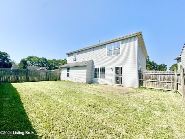 rear view of house with a lawn and a patio area