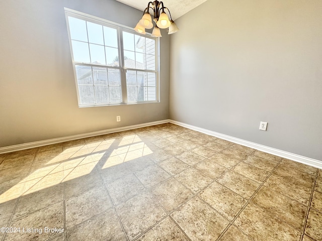 unfurnished room featuring a textured ceiling and an inviting chandelier