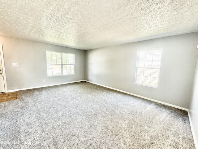 carpeted empty room with a textured ceiling