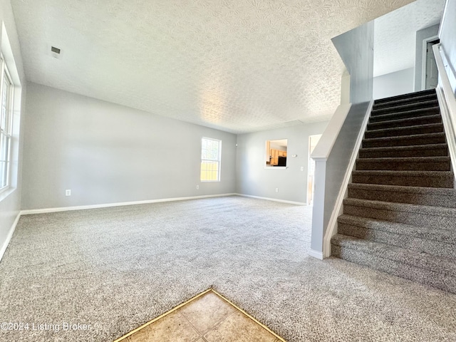 interior space with carpet floors and a textured ceiling