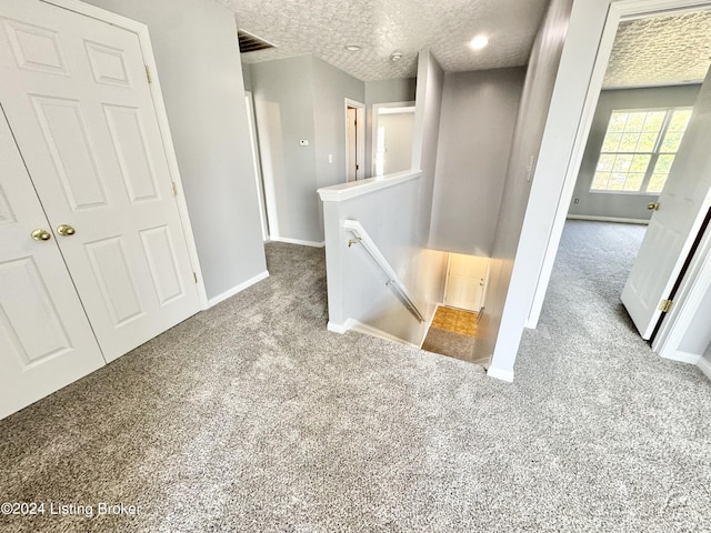 interior space featuring light colored carpet and a textured ceiling