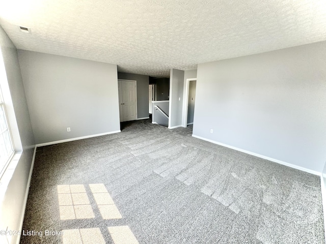 empty room featuring carpet flooring and a textured ceiling