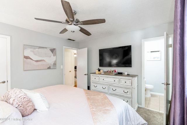 bedroom featuring connected bathroom, ceiling fan, light carpet, and a textured ceiling