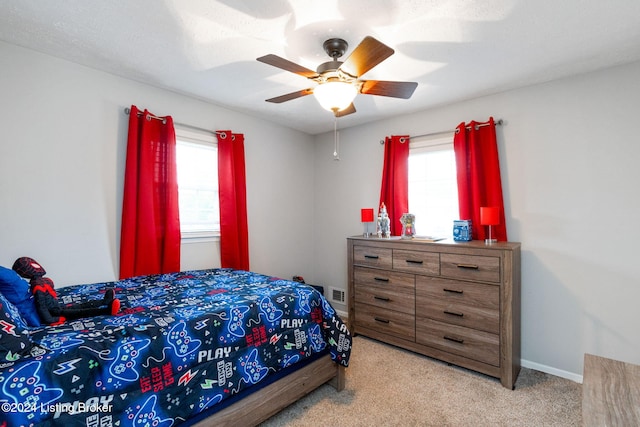 bedroom with a textured ceiling, light colored carpet, and ceiling fan