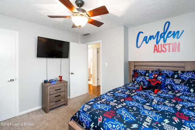 bedroom with carpet, ceiling fan, and a textured ceiling