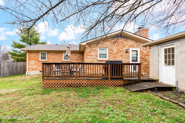 back of property featuring a lawn and a wooden deck