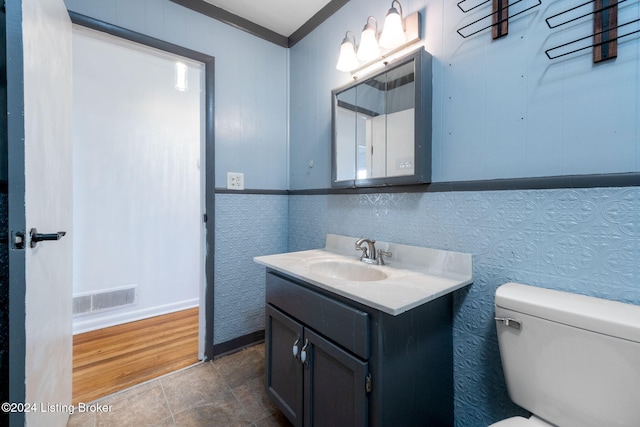 bathroom featuring ornamental molding, vanity, and toilet