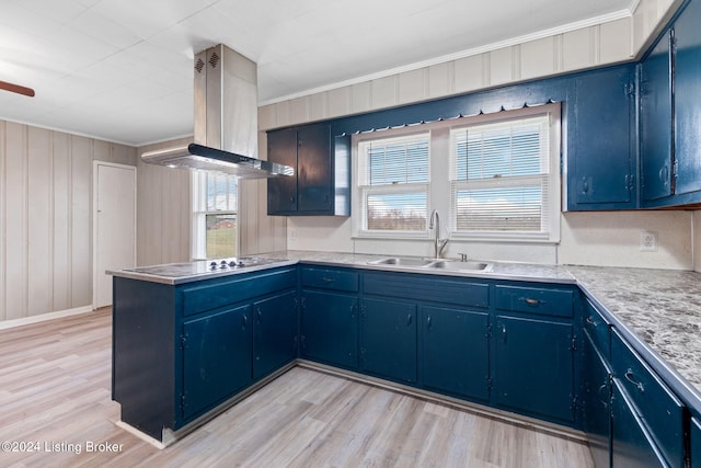 kitchen featuring electric cooktop, sink, blue cabinetry, and island exhaust hood