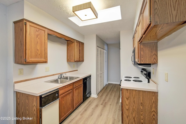 kitchen featuring range with electric stovetop, dishwasher, sink, light wood-type flooring, and a textured ceiling