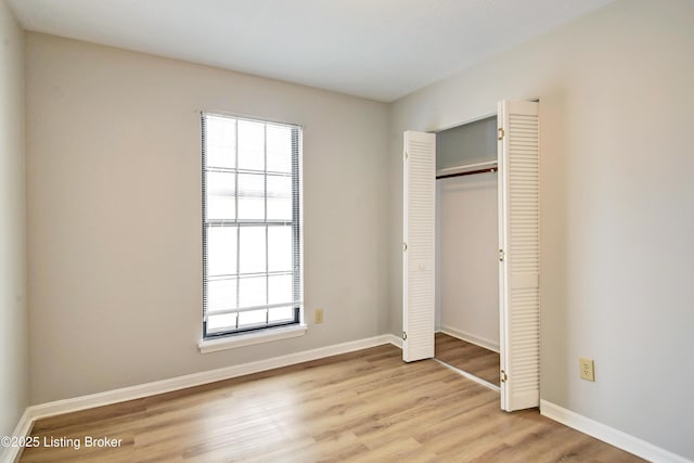 unfurnished bedroom featuring light hardwood / wood-style floors and a closet