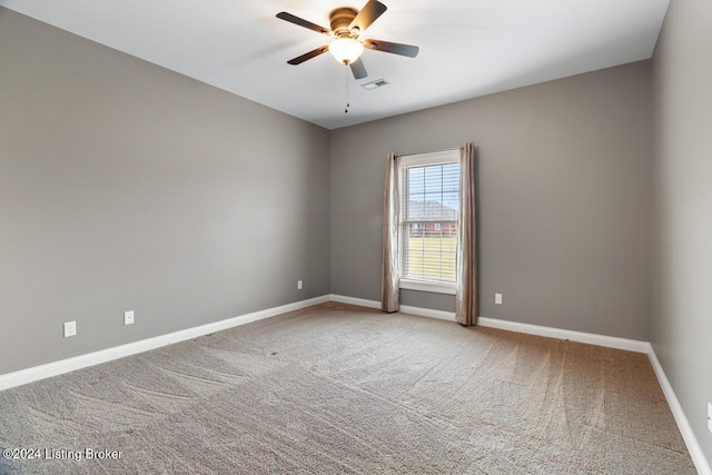 carpeted spare room featuring ceiling fan