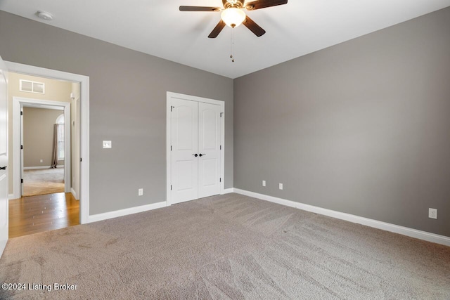 unfurnished bedroom featuring ceiling fan, carpet floors, and a closet