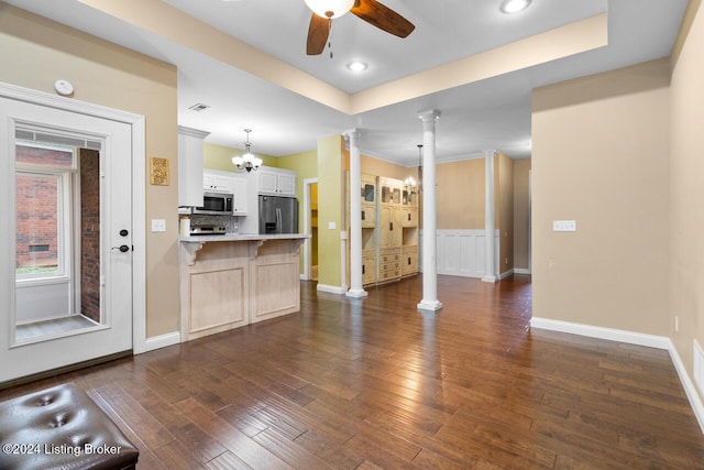 kitchen with ceiling fan with notable chandelier, appliances with stainless steel finishes, decorative light fixtures, white cabinetry, and decorative columns