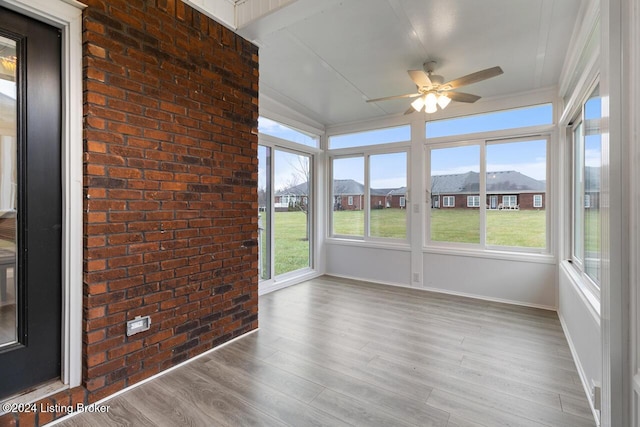 unfurnished sunroom with ceiling fan and a mountain view