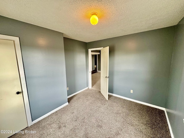 spare room with carpet flooring and a textured ceiling