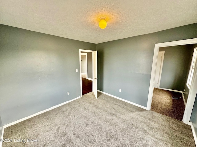 unfurnished bedroom featuring carpet and a textured ceiling