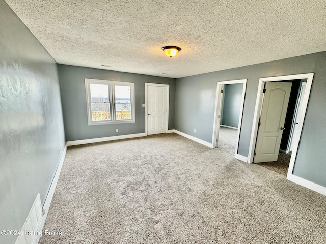 empty room featuring carpet flooring and a textured ceiling