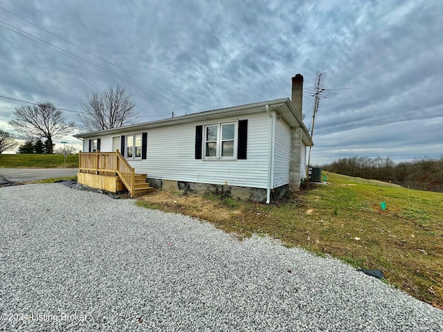 view of home's exterior with cooling unit and a lawn