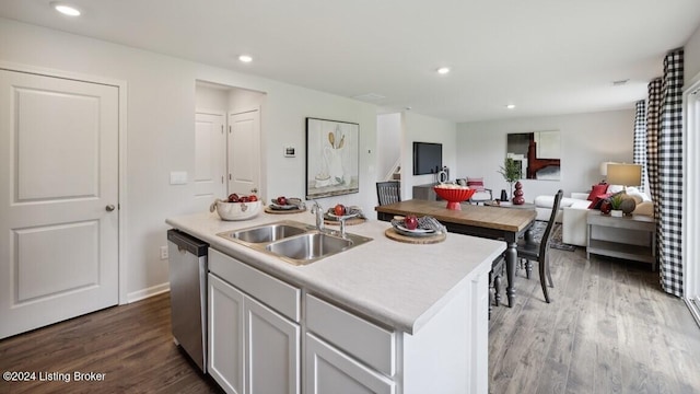 kitchen featuring hardwood / wood-style floors, dishwasher, a center island with sink, white cabinets, and sink