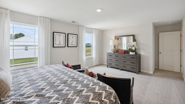 bedroom with light carpet and multiple windows