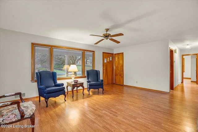 sitting room with ceiling fan and light hardwood / wood-style flooring