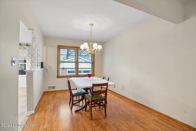 dining space featuring light hardwood / wood-style floors and an inviting chandelier