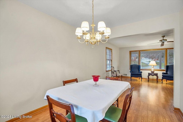 dining area featuring ceiling fan with notable chandelier and light hardwood / wood-style flooring