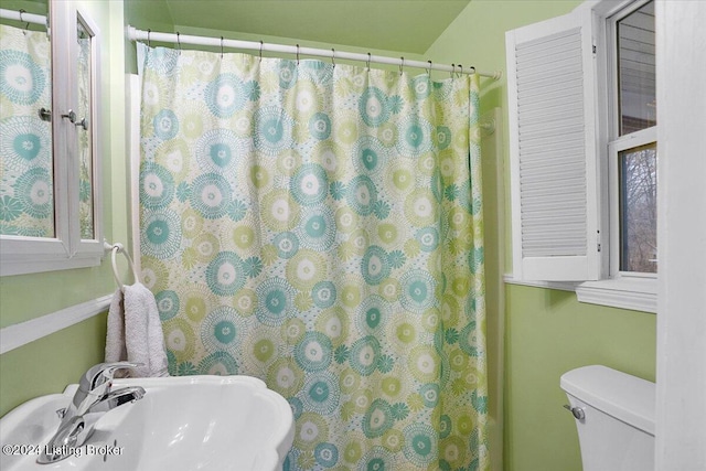 bathroom with a shower with curtain, toilet, and sink