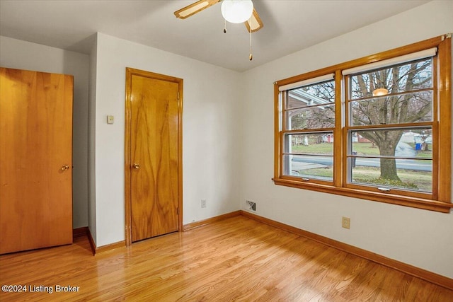 unfurnished bedroom featuring ceiling fan, light hardwood / wood-style floors, and a closet